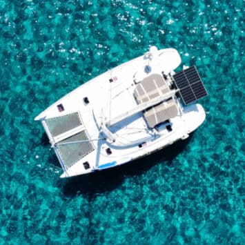 Katamaran Galerie Sardinien - Luftaufnahme des Catamaran Discovery vor der Ostküste Sardiniens – Tagescharter auf kristallklarem Wasser.