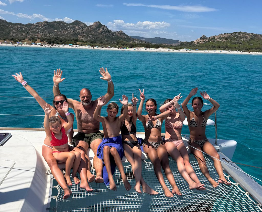 Gäste genießen eine Katamaran Tagestour ab La Caletta an der Küste von Sardinien.