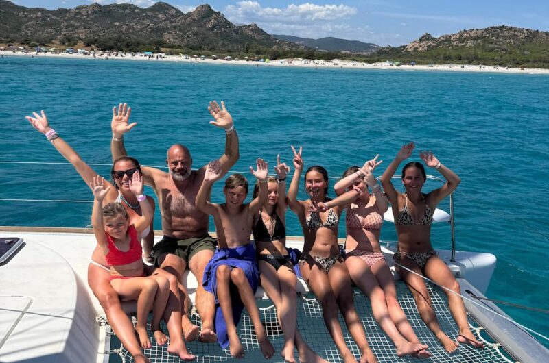Gäste genießen eine Katamaran Tagestour ab La Caletta an der Küste von Sardinien.